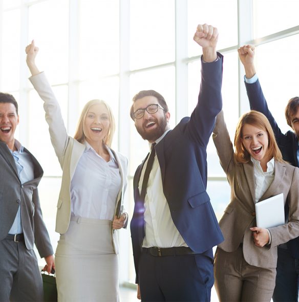 Group of ecstatic business partners looking at camera with raised arms